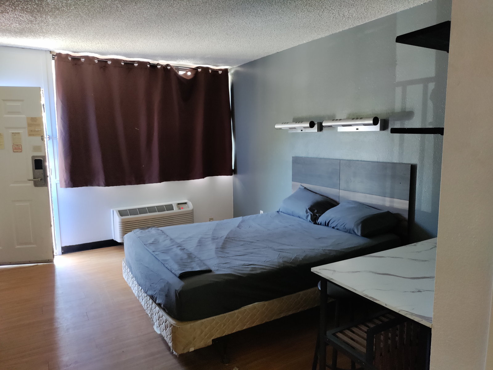 Studio with a bed by the window and a work table